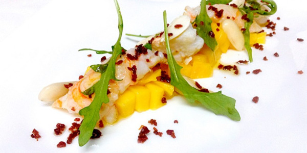 Tartar de mango con cigalas, rúcula y jamón